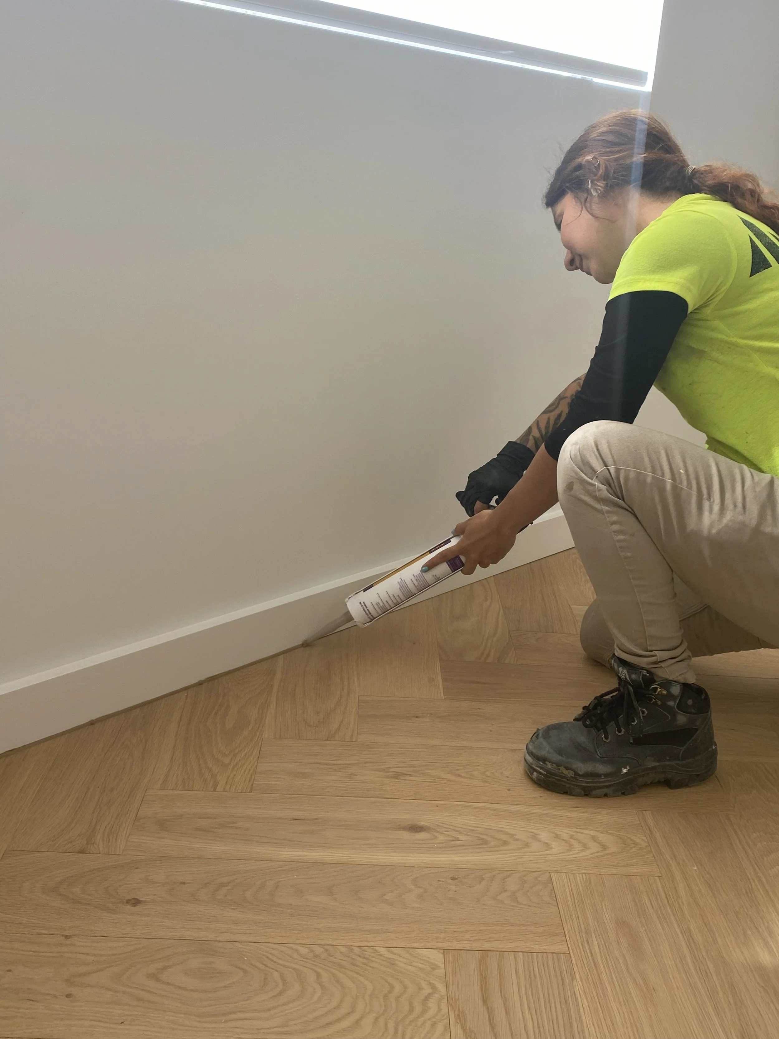 Caulking the skirting to timber floor junction on a residential fit-out